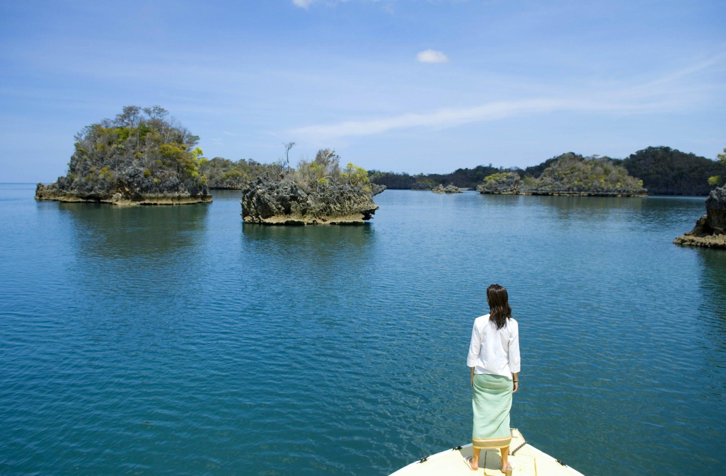 A woman on a rock looking over the islets of Moramba Bay